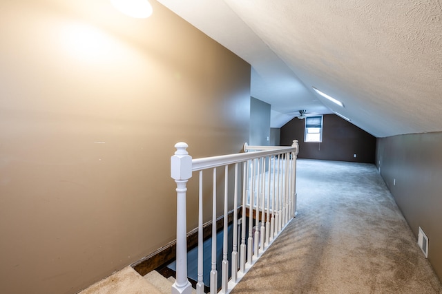 additional living space with carpet, a textured ceiling, and vaulted ceiling
