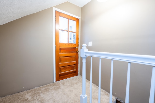 doorway with carpet and a textured ceiling