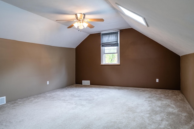 bonus room featuring ceiling fan, lofted ceiling with skylight, and carpet floors