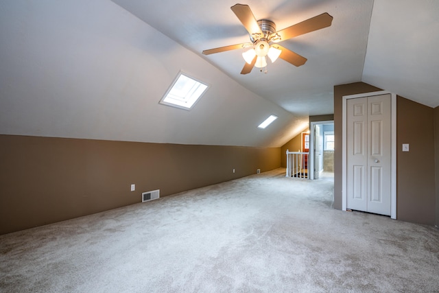 bonus room with carpet floors, lofted ceiling with skylight, and a wealth of natural light