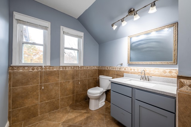 bathroom with tile patterned floors, tile walls, and vaulted ceiling