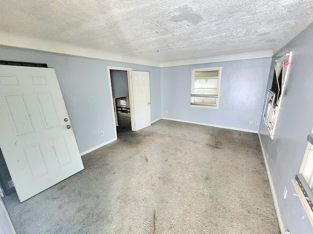 carpeted empty room with a textured ceiling