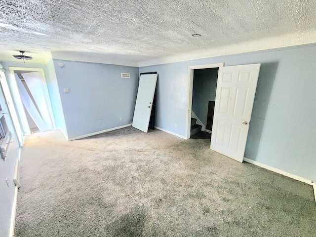 carpeted spare room featuring a textured ceiling