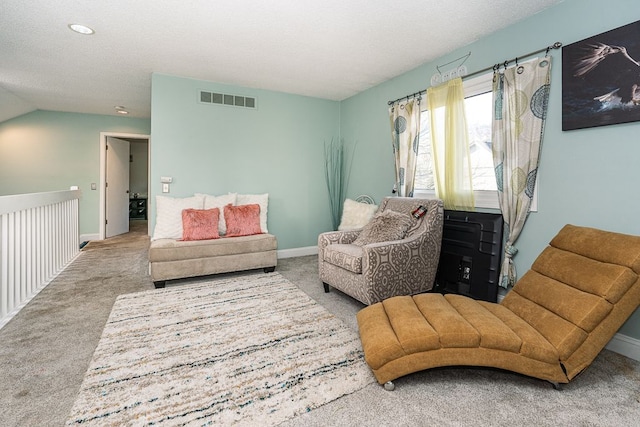 sitting room featuring carpet floors and vaulted ceiling