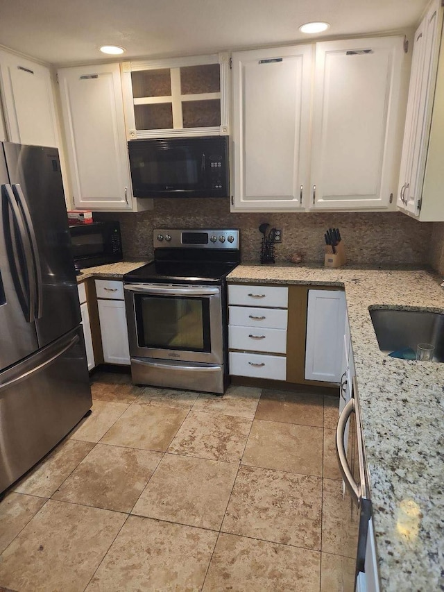 kitchen featuring white cabinets, stainless steel appliances, backsplash, and light stone countertops