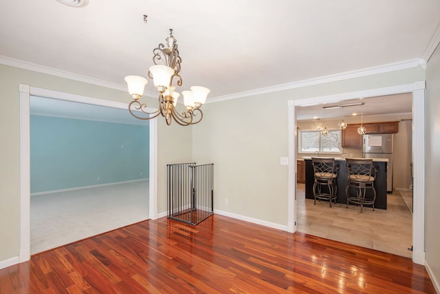 spare room with crown molding, dark hardwood / wood-style floors, and a notable chandelier