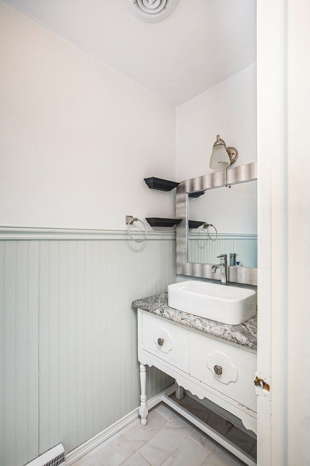 bathroom with vanity and wood walls