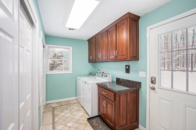 washroom with washing machine and dryer, light tile patterned floors, and cabinets