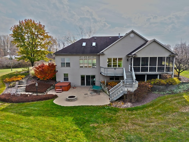 rear view of house featuring a yard, a hot tub, a patio area, and a sunroom