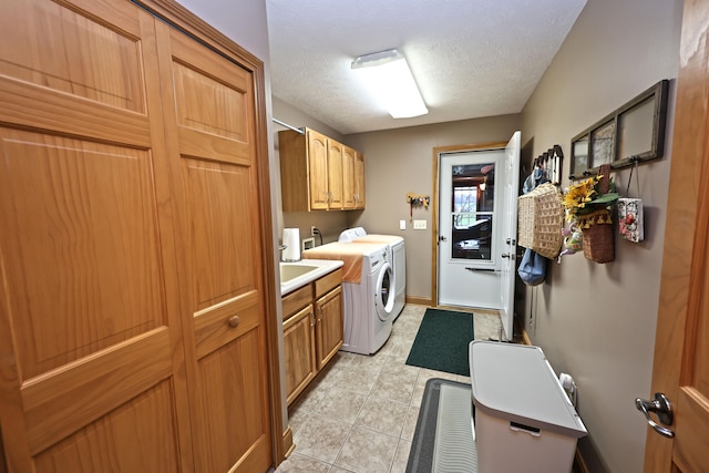 laundry room with separate washer and dryer, light tile patterned floors, cabinets, and a textured ceiling