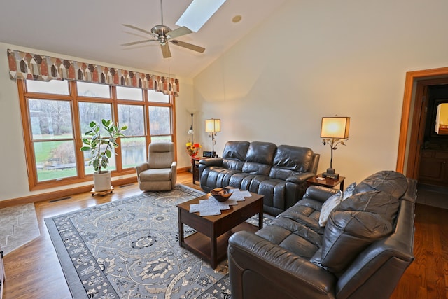 living room with wood-type flooring, a skylight, high vaulted ceiling, and ceiling fan