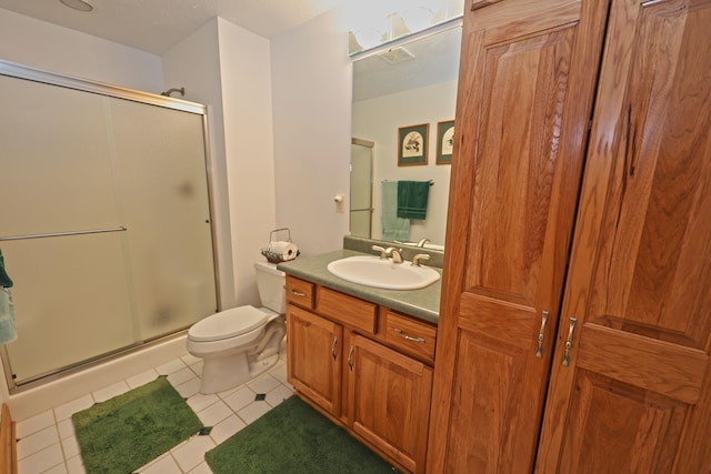 bathroom with toilet, tile patterned flooring, vanity, and walk in shower