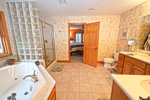 full bathroom featuring vanity, toilet, a textured ceiling, and independent shower and bath