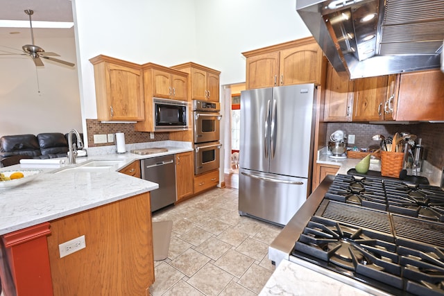 kitchen featuring sink, decorative backsplash, ceiling fan, range hood, and appliances with stainless steel finishes