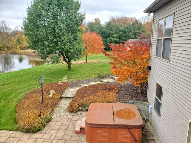 view of yard featuring a water view and a hot tub