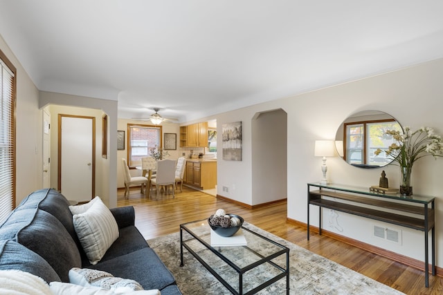 living room featuring ceiling fan and light hardwood / wood-style flooring