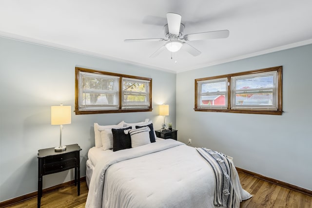 bedroom featuring ceiling fan, crown molding, and hardwood / wood-style flooring