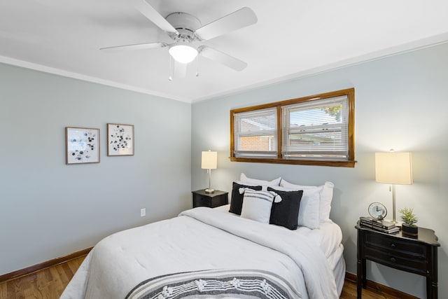 bedroom featuring ceiling fan, wood-type flooring, and ornamental molding