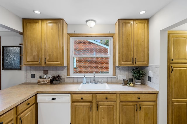 kitchen with backsplash, white dishwasher, and sink