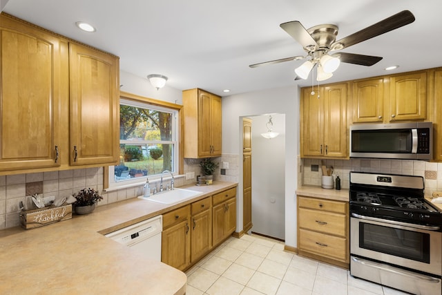 kitchen with tasteful backsplash, stainless steel appliances, ceiling fan, sink, and light tile patterned floors