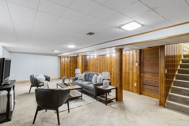 living room featuring light carpet and wooden walls