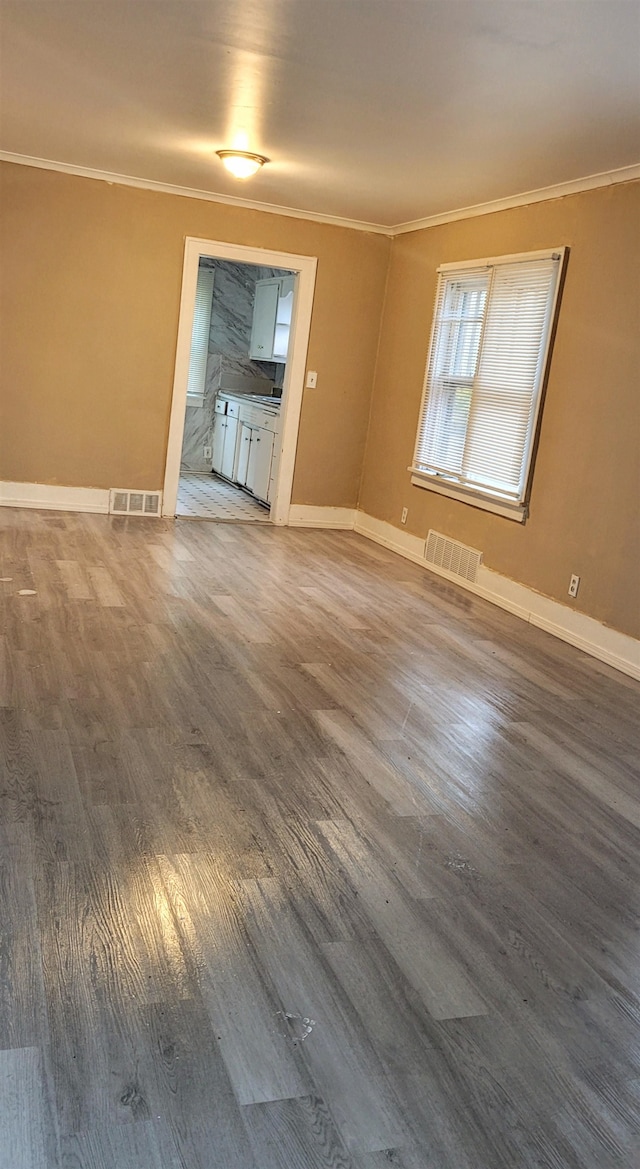 unfurnished living room with dark hardwood / wood-style floors and ornamental molding