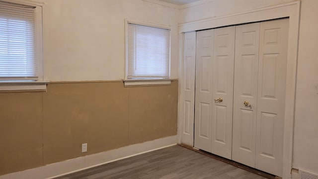 unfurnished bedroom featuring hardwood / wood-style floors and a closet