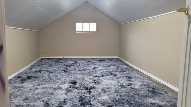 additional living space with carpet flooring and lofted ceiling