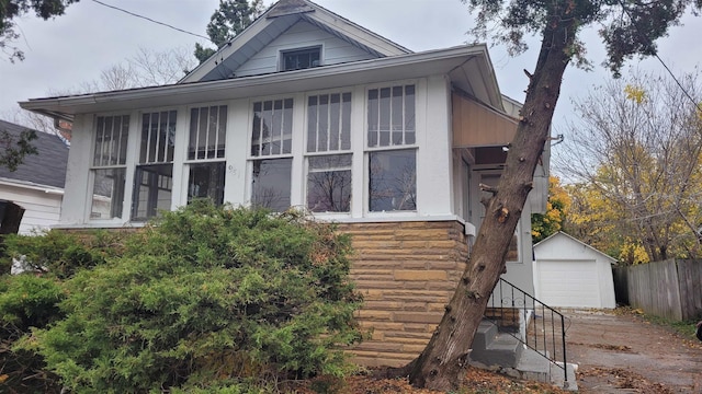 931 Hughes Ave, Flint, MI 48503 - view of home's exterior featuring driveway, a detached garage, and an outdoor structure