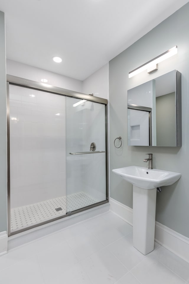 bathroom featuring tile patterned floors, an enclosed shower, and sink