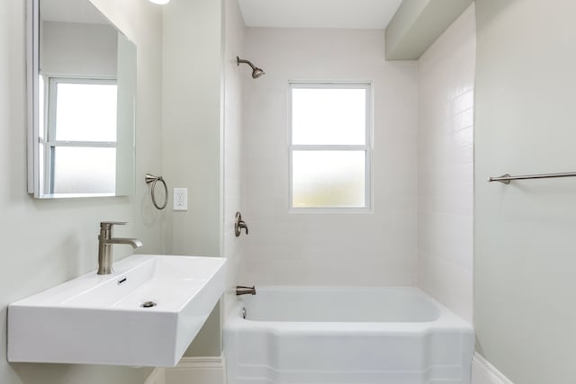 bathroom with tiled shower / bath combo and sink