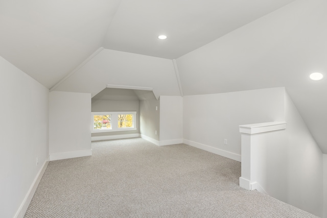 bonus room featuring light carpet and vaulted ceiling