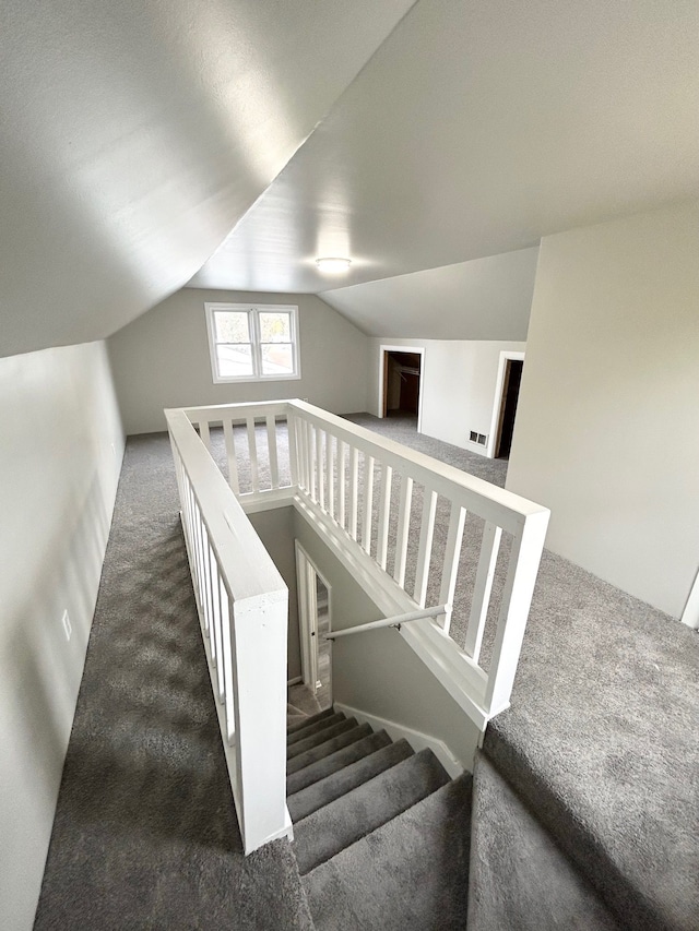 staircase with carpet floors and vaulted ceiling