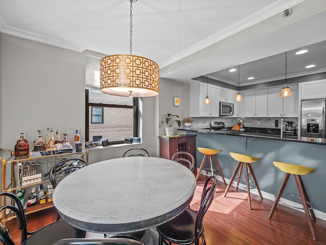 dining space featuring ornamental molding and dark wood-type flooring