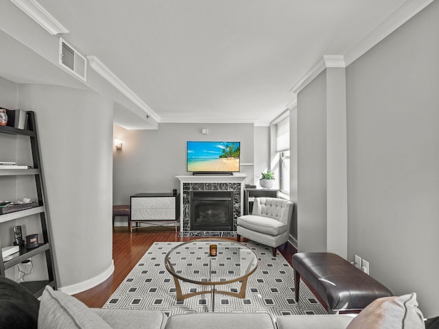 living room with dark hardwood / wood-style floors, crown molding, and a fireplace