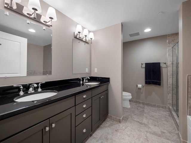 bathroom featuring vanity, toilet, and an enclosed shower