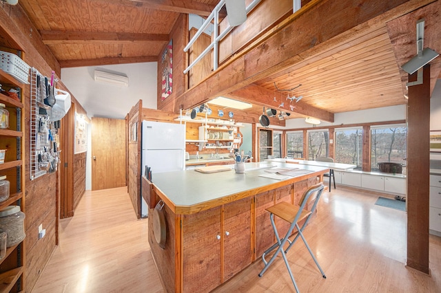 kitchen with vaulted ceiling with beams, light hardwood / wood-style floors, wooden walls, and wood ceiling