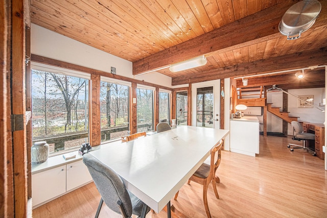 dining room featuring beam ceiling, wood ceiling, and light wood-type flooring