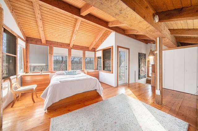 bedroom featuring lofted ceiling with beams, light hardwood / wood-style flooring, and wooden ceiling