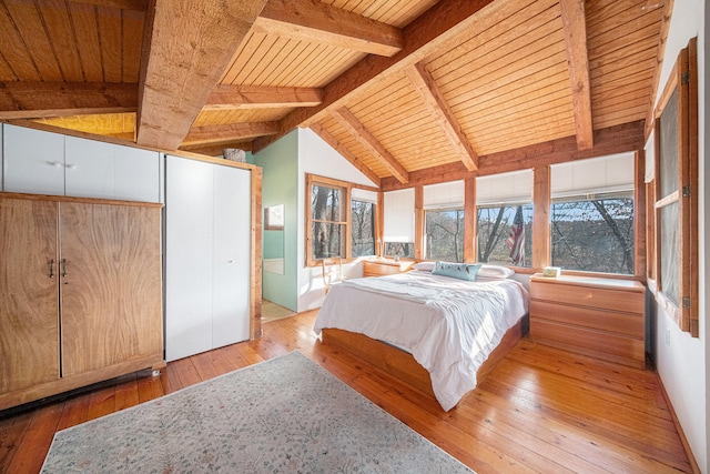 bedroom featuring lofted ceiling with beams, light hardwood / wood-style floors, and wood ceiling