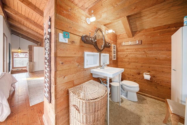 bathroom with hardwood / wood-style floors, vaulted ceiling with beams, wood walls, and wood ceiling