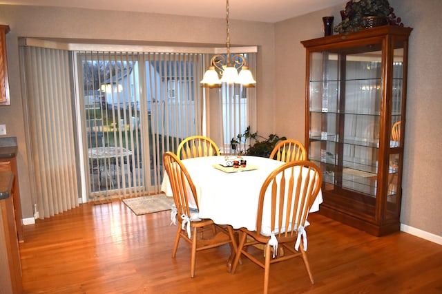 dining room with wood-type flooring, an inviting chandelier, and a healthy amount of sunlight