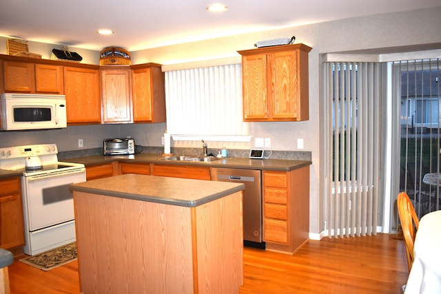 kitchen featuring sink, a center island, white appliances, and light hardwood / wood-style flooring