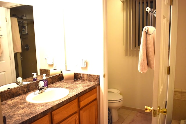 bathroom featuring tile patterned flooring, vanity, and toilet