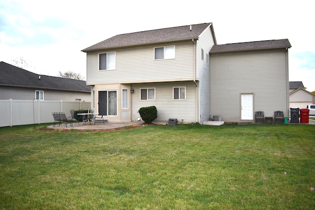 back of house featuring a lawn and a patio area