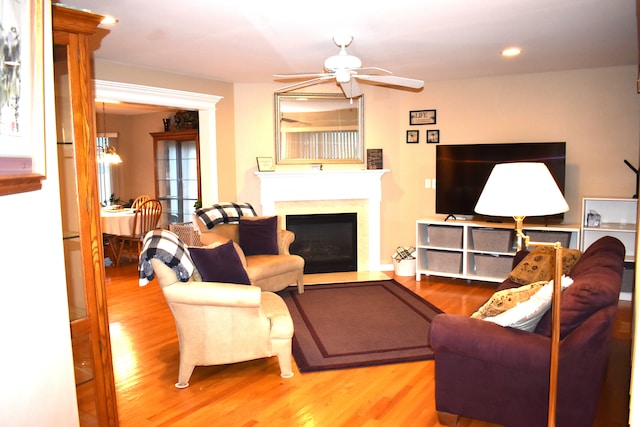 living room featuring hardwood / wood-style flooring and ceiling fan with notable chandelier