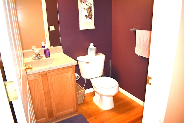 bathroom with vanity, toilet, and wood-type flooring