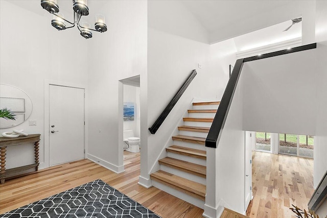 foyer with light wood-type flooring, an inviting chandelier, and high vaulted ceiling