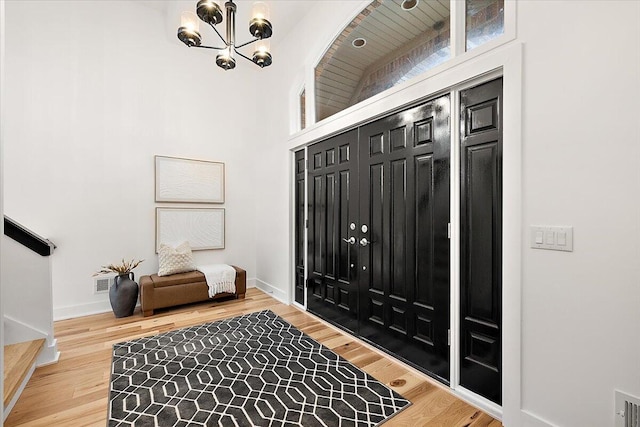 interior space with hardwood / wood-style flooring, a high ceiling, and an inviting chandelier