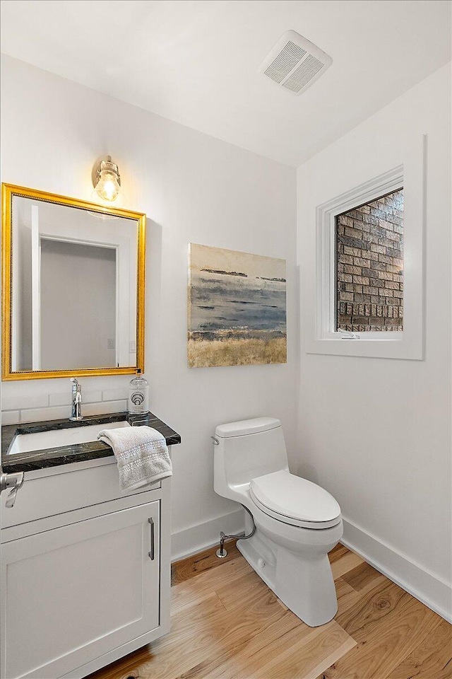 bathroom featuring wood-type flooring, vanity, and toilet